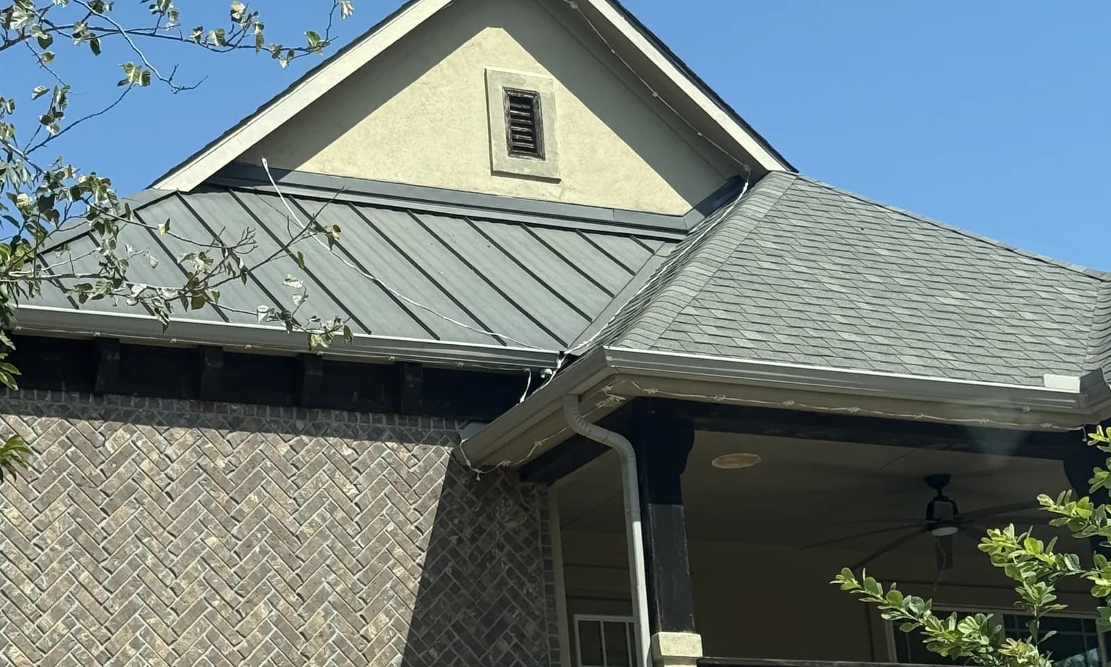 Two exposed Govee cables hanging loose across a standing-seam metal roof below a gable, with more cable along the gutter line