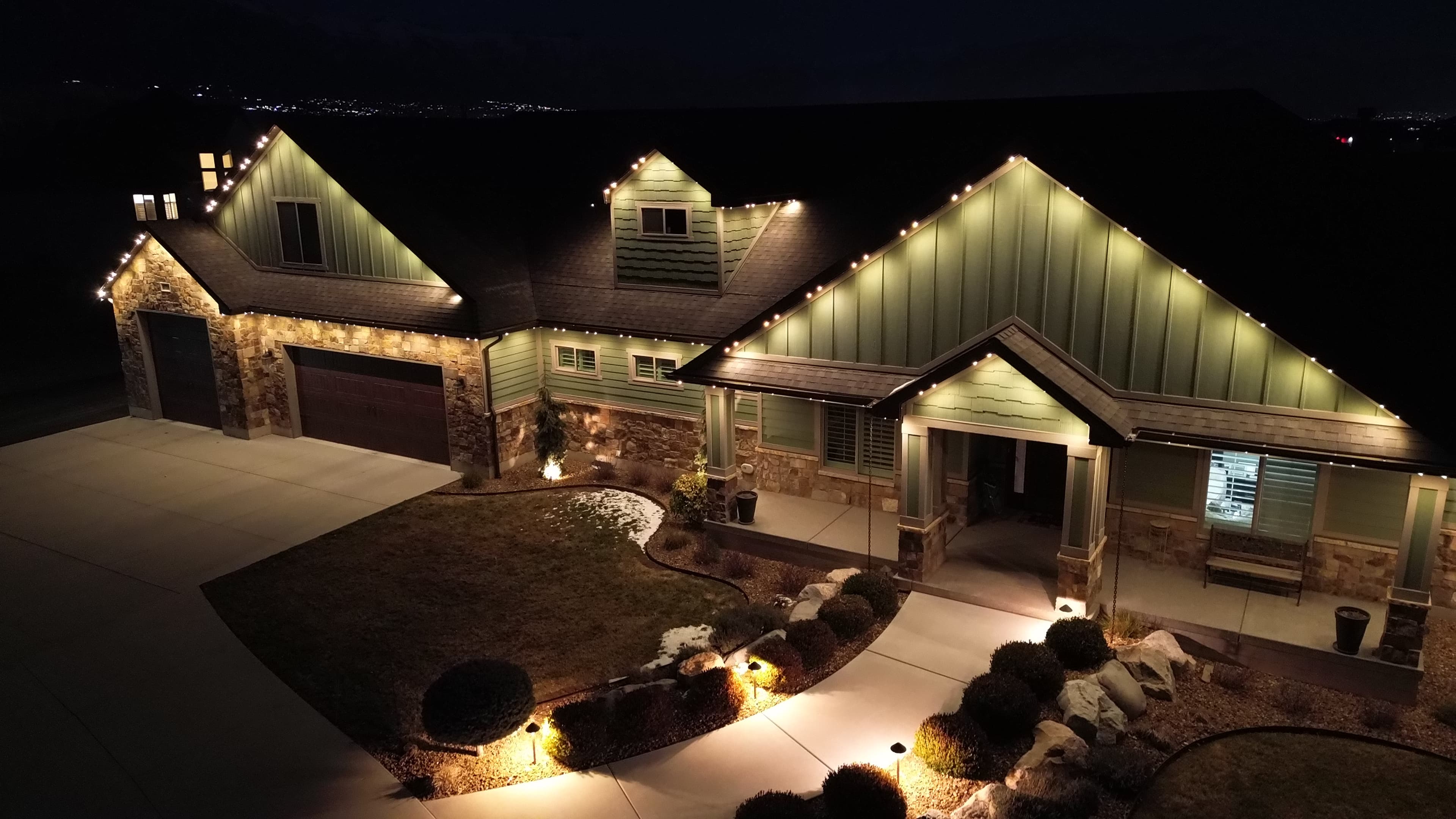 Warm-white lighting on a home, front walkway, and surrounding garden beds
