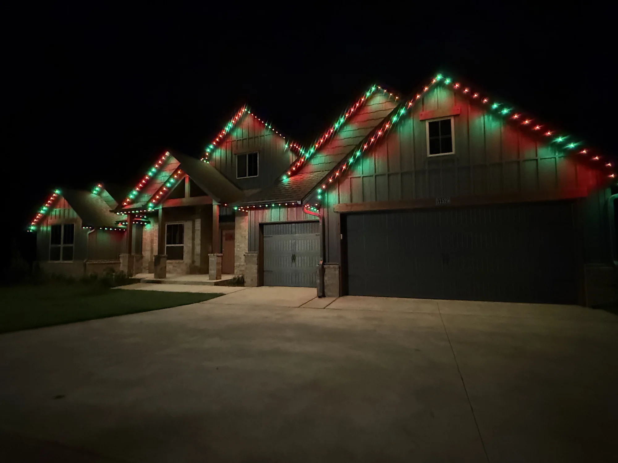 Red and green TruLight roofline lights on a gabled Oklahoma home.