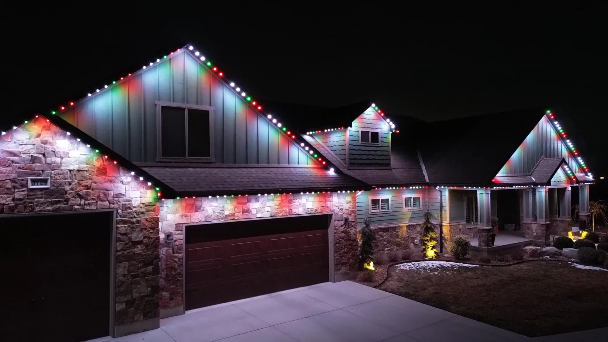 Stone home with TruLight permanent lighting for the holidays