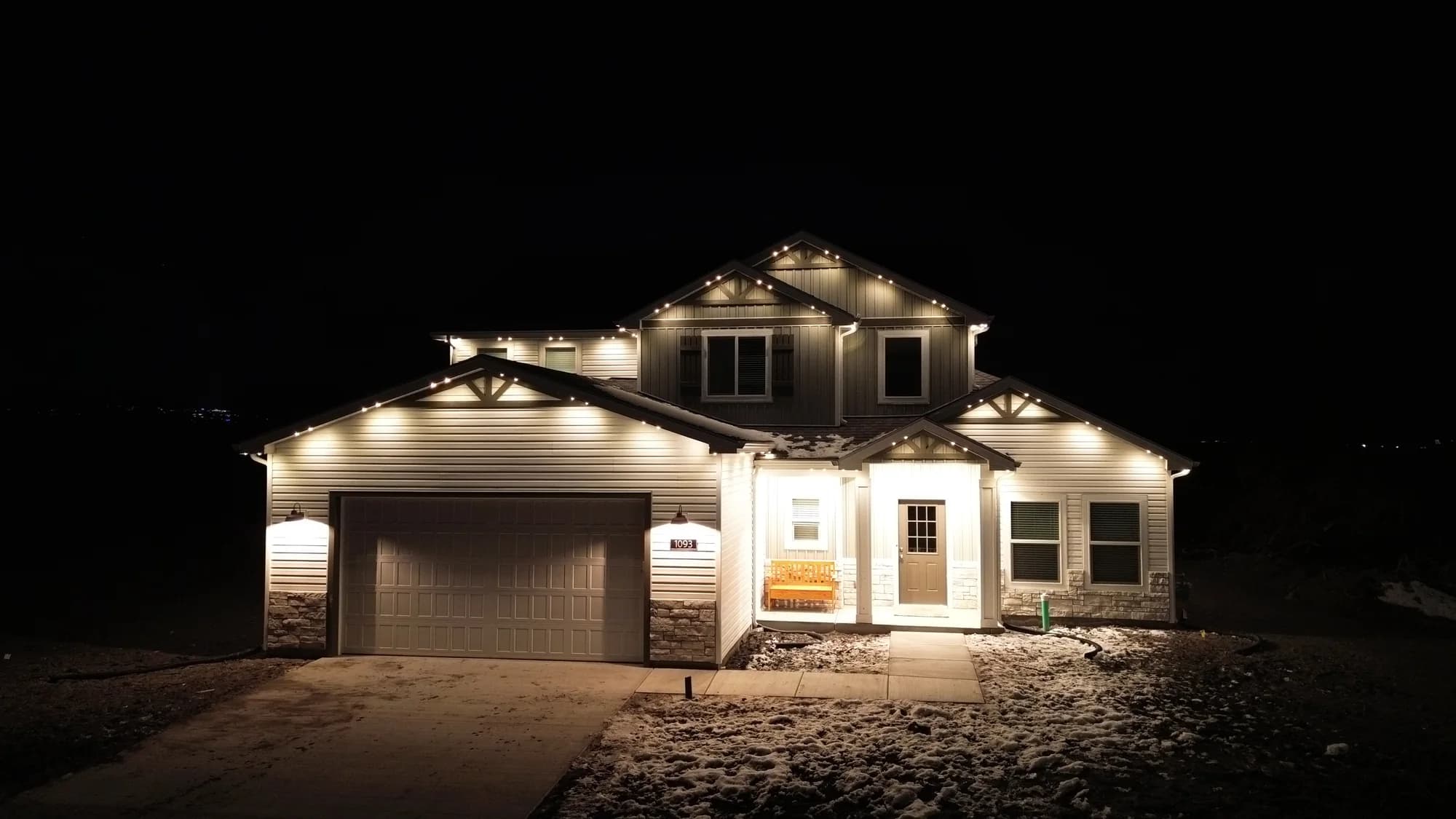 Warm-white TruLight accents on a Utah home with timber gables and snow on the lawn.